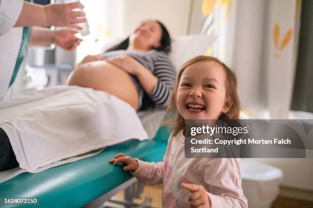 a pregnant mother and her first born child in a clinic - oslo city life stock pictures, royalty-free photos & images