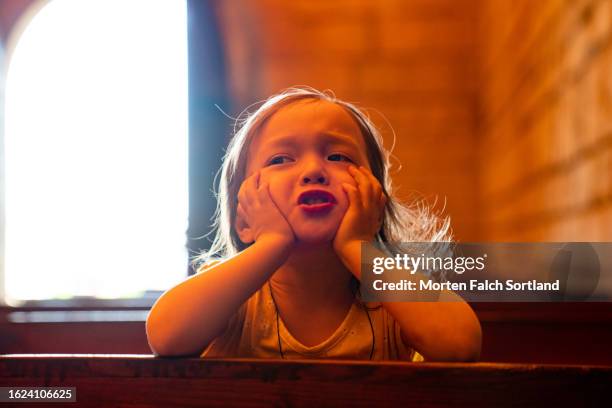 a child visiting an old church - kirchenbank stock-fotos und bilder