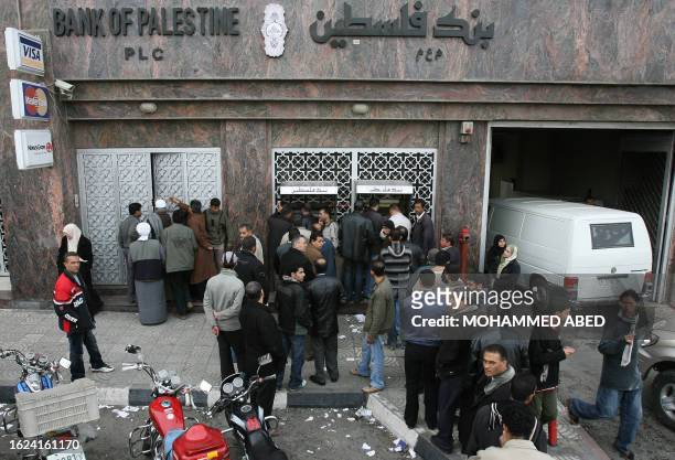 Palestinians crowd outside a bank in Gaza City on the first day banks are open since the start of Israel's 22-days military offensive in the...