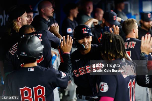 Andres Gimenez of the Cleveland Guardians celebrates a solo home run with teammates in the dugout during the eighth inning of their MLB game against...