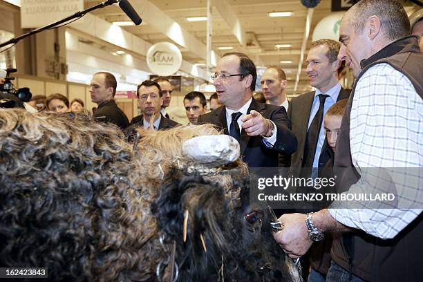 Breeder presents his bull to French President Francois Hollande , flanked by Junior Minister for Food Industry Guillaume Garot who visits the 50th...