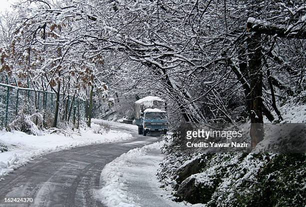An Indian paramilitary vehicle drives on road amid a snowfall on February 23, 2013 in Srinagar, Indian Administered Kashmir, India. Several parts of...