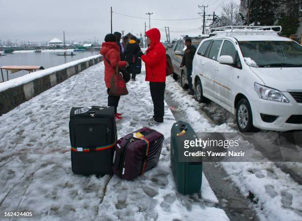 Tourist alight from vehicles to enter houseboats after a snowfall on February 23, 2013 in Srinagar, Indian Administered Kashmir, India. Several parts...