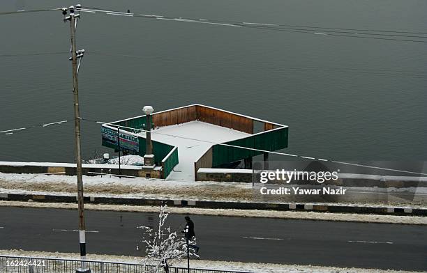 Man walks on a road after a snowfall on February 23, 2013 in Srinagar, Indian Administered Kashmir, India. Several parts of the Kashmir Valley,...