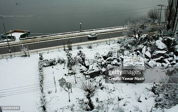 Vehicle passes on the road after a snowfall on February 23, 2013 in Srinagar, Indian Administered Kashmir, India. Several parts of the Kashmir...