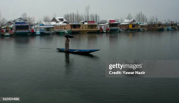 Kashmiri man rows his boat on the waters of Dal lake after a snowfall on February 23, 2013 in Srinagar, Indian Administered Kashmir, India. Several...