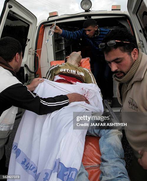 Palestinians paramedics load a wounded proterstor onto an ambulance following clashes with settlers in the West Bank village of Qusra near Nablus on...