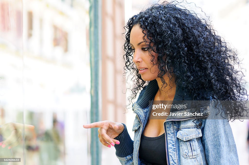 Black woman looking at the shop window