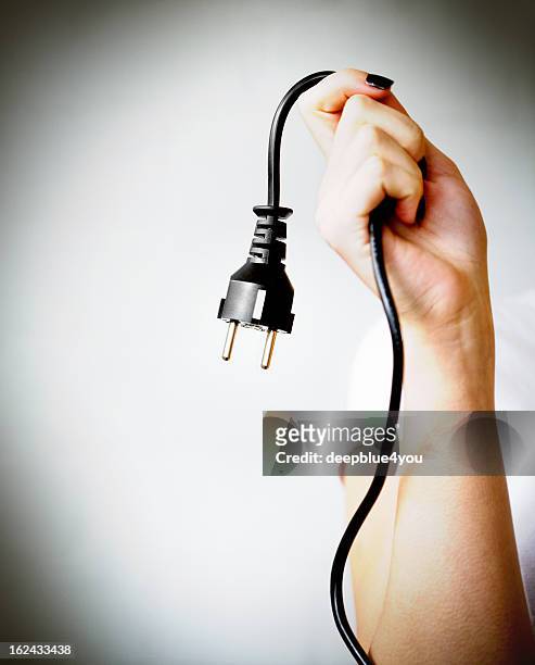 woman hand holding black electric cable with plug type f - network connection stock pictures, royalty-free photos & images