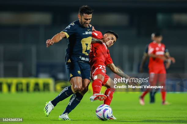 Eduardo Salvio of Pumas battles for the ball against Claudio Baeza of Toluca during the 4th round match between Pumas UNAM and Toluca as part of the...