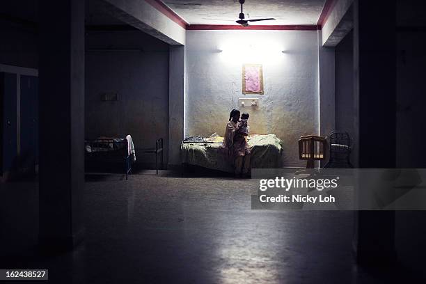 Caretaker looks after Kavitha inside a room at the Aarti Home shelter on February 21, 2013 in Kadapa, India. Kavitha was sent into the orphanage in...