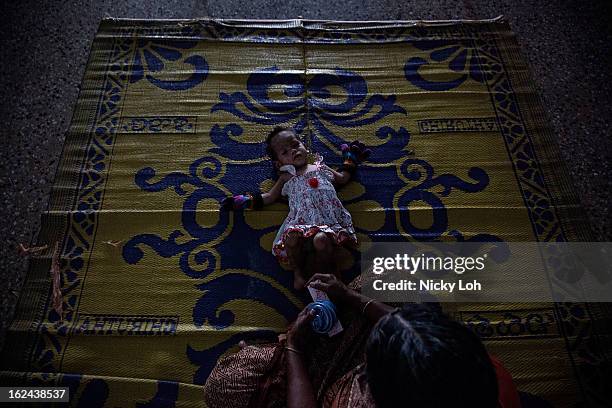 Caretaker looks after Kavitha inside a room at the Aarti Home shelter on February 21, 2013 in Kadapa, India. Kavitha was sent into the orphanage in...