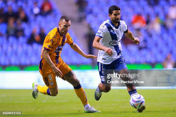 Leo Bonatini of Atletico San Luis battles for possession with Diego de Buen of Puebla during the 4th round match between Puebla and Atletico San Luis...