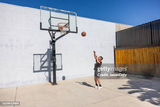 jungen basketball spielen - basketball teenager stock-fotos und bilder