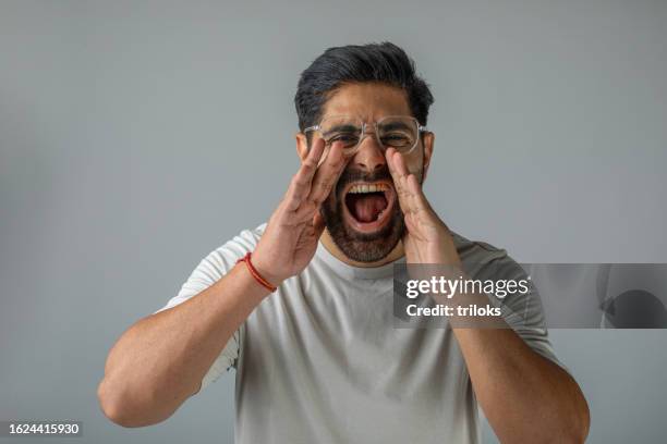 handsome man shouting in anger over white background - screaming stock pictures, royalty-free photos & images