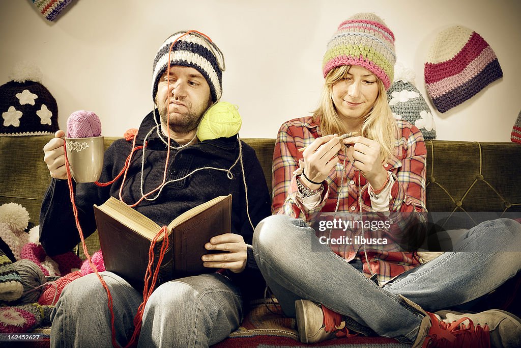 Annoying young knitter woman couple portrait on couch