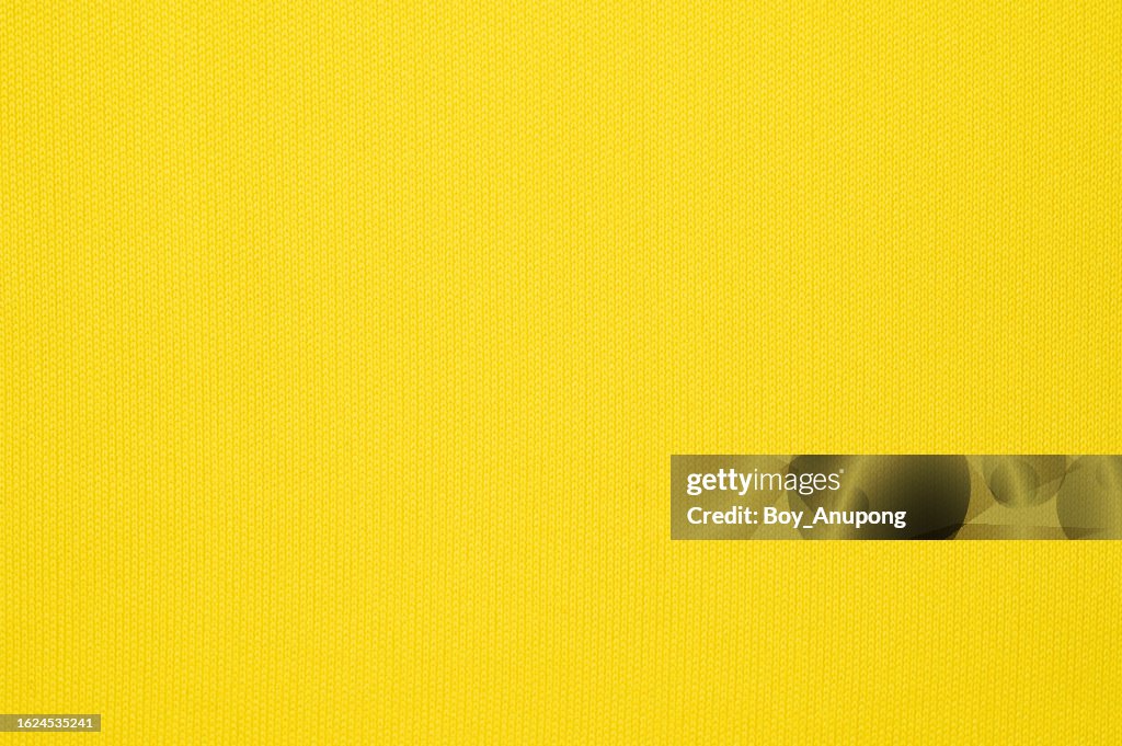 Full frame shot of yellow polyester fabric texture and background.