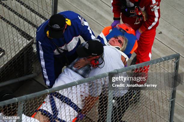 Emergency officials remove an injured fan from the stands following an incident at the finish of the NASCAR Nationwide Series DRIVE4COPD 300 at...