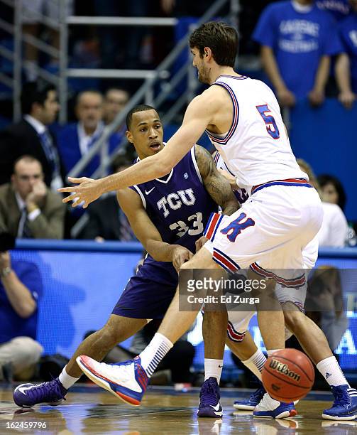 Garlon Green of the TCU Horned Frogs passes around Jeff Withey of the Kansas Jayhawks at Allen Field House on February 23, 2013 in Lawrence, Kansas.