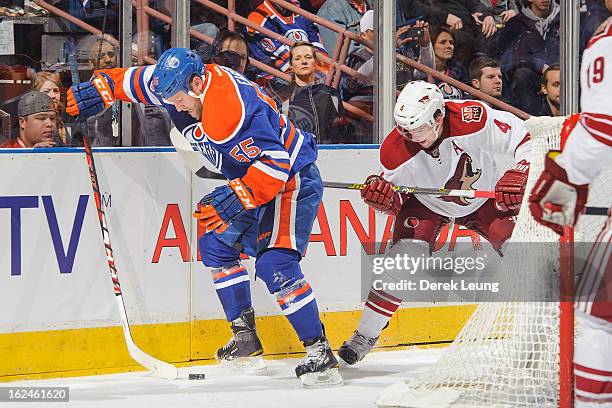 Ben Eager of the Edmonton Oilers battles for the puck against Zbynek Michalek of the Minnesota Wild during an NHL game at Rexall Place on February...