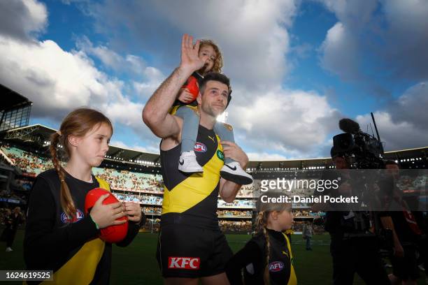 Teary eyed Trent Cotchin of the Tigers waves to fans as he walks a lap of honour with his family after playing his final game during the round 23 AFL...