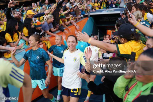 Aivi Luik of Australia and Elin Rubensson of Sweden high five with fans as they walk out for the warm up prior to the FIFA Women's World Cup...