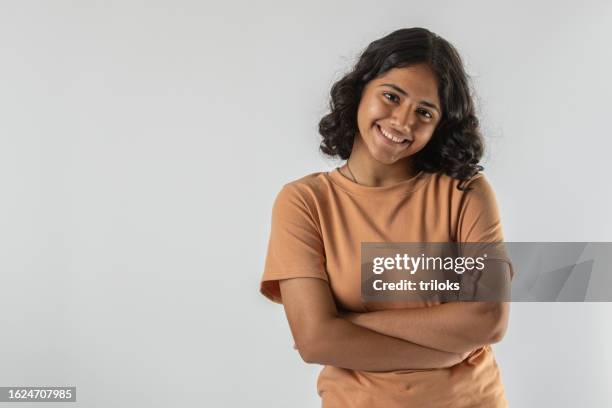 smiling teenage girl with arms crossed over white background - one teenage girl only stockfoto's en -beelden