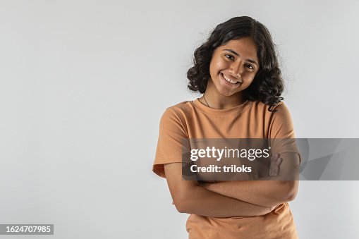 Smiling teenage girl with arms crossed over white background Smiling teenage girl with arms crossed over white background