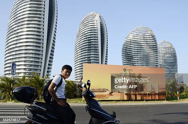 China-economy-property-Hainan,FEATURE by Tom Hancock This picture taken on January 19, 2013 shows a Chinese man sitting on a motorbike in front of...