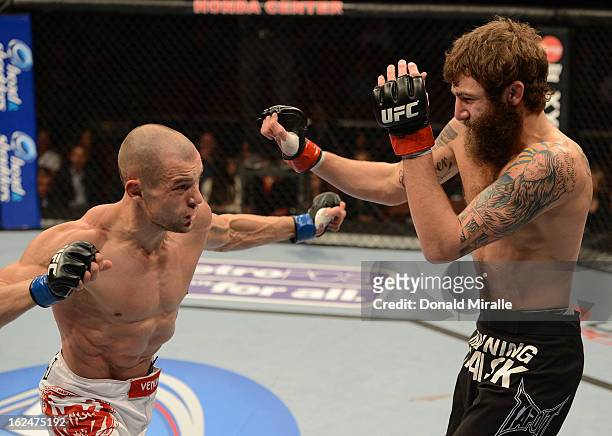 Anton Kuivanen punches Michael Chiesa in their lightweight bout during UFC 157 at Honda Center on February 23, 2013 in Anaheim, California.