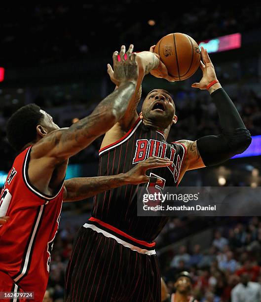 Carlos Boozer of the Chicago Bulls shoots against Udonis Haslem of the Miami Heat at the United Center on February 21, 2013 in Chicago, Illinois. The...