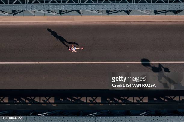 This aerial picture taken on August 26, 2023 shows an athlete running across the Chain Bridge while competing in the women's marathon final during...
