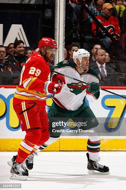 Akim Aliu of the Calgary Flames skates against Clayton Stoner of the Minnesota Wild on February 23, 2013 at the Scotiabank Saddledome in Calgary,...