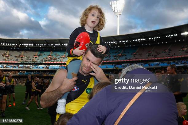 Teary eyed Trent Cotchin of the Tigers walks a lap of honour with his family after playing his final game during the round 23 AFL match between...