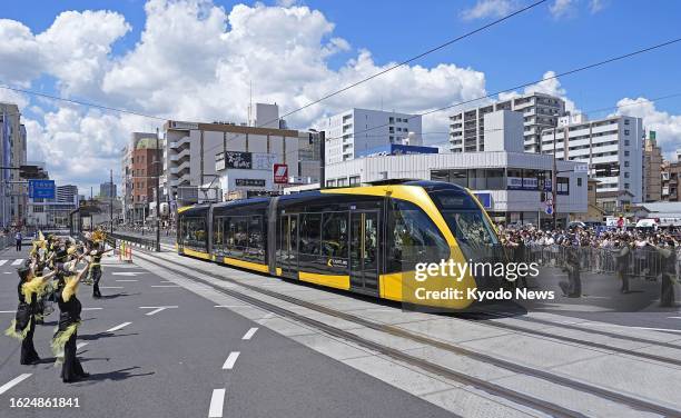 Light rail transit train carrying children and others runs through Utsunomiya in Tochigi Prefecture, north of Tokyo, after a ceremony commemorating...