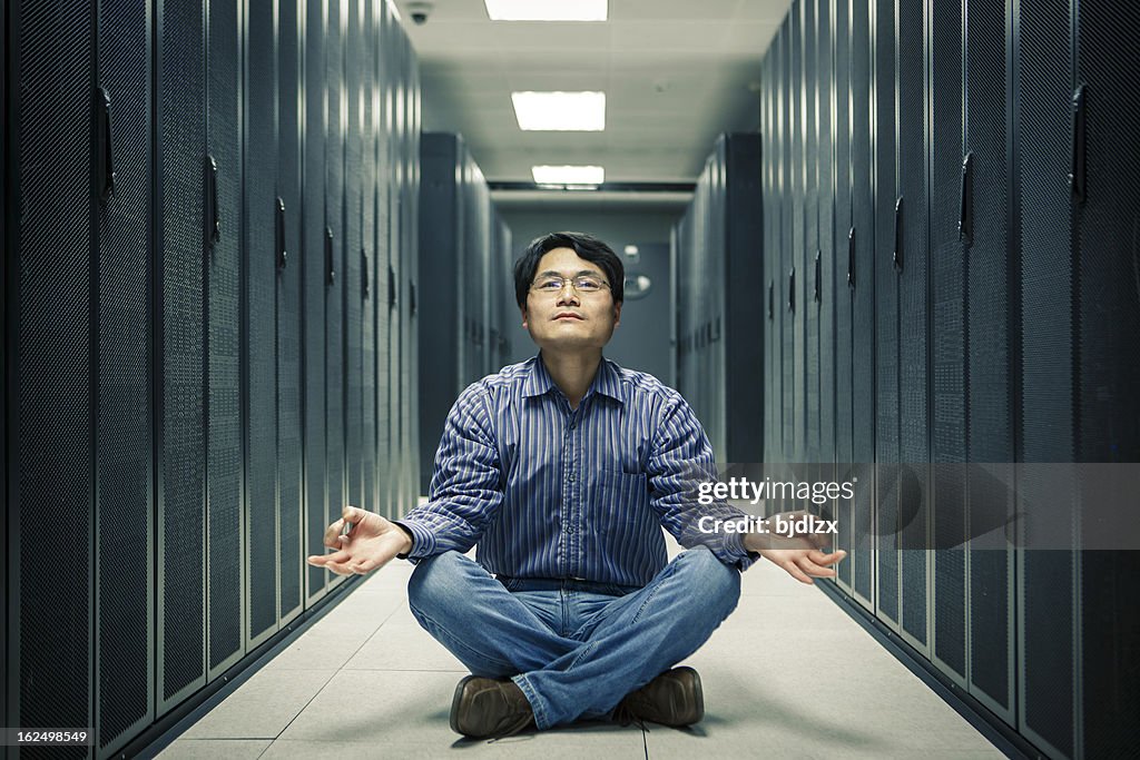 Business man practice yoga at network server room