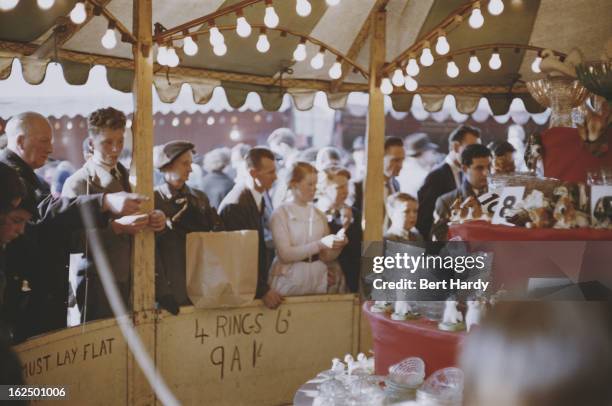 Londoners at a hoopla stall at an Easter Fair, held on Hampstead Heath, London, 1956. Original publication: Picture Post - Easter Fair - unpub