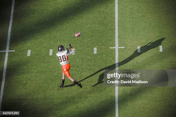 american football player catching a pass. - football jersey stock pictures, royalty-free photos & images