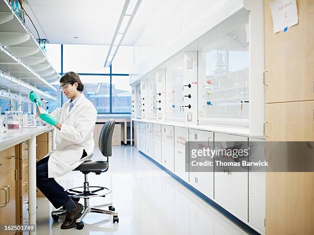 scientist using pipette in research laboratory - scientist full length stock pictures, royalty-free photos & images