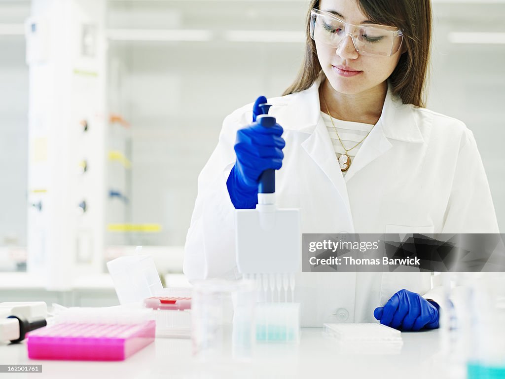 Scientist using multichannel pipetter in lab