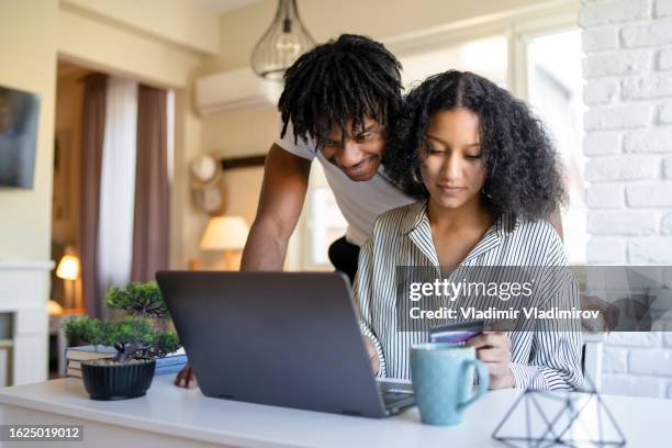 un marido y una mujer comprando en línea desde casa - plano fijo fotografías e imágenes de stock