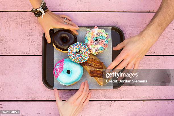 specialty doughnuts on a tray. - hand raised stock-fotos und bilder