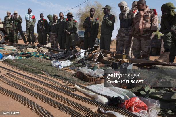 Soldiers stand in front of weapons and ammunitions seized from Islamist fighters exhibited by the Malian army in the centre of Gao on February 24,...