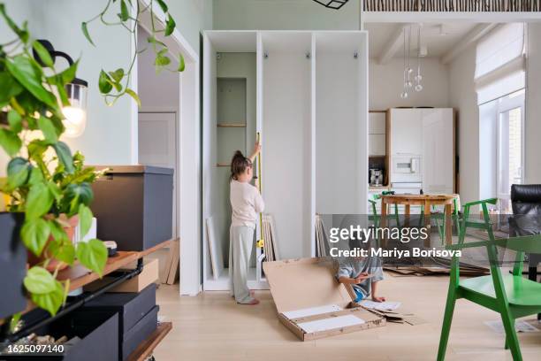 a boy and a girl collects a closet in a bright room at home. - cleaning up after party stock pictures, royalty-free photos & images