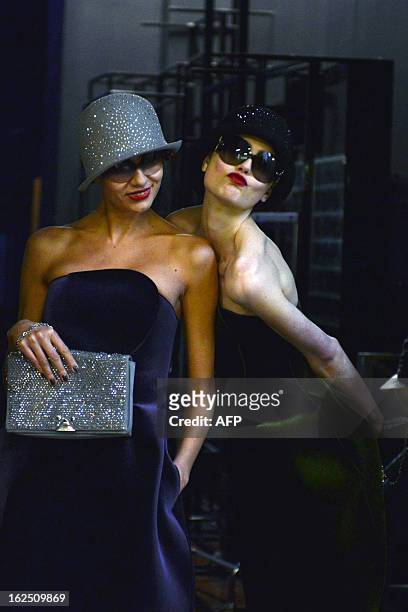 Models arrive backstage after walking on the catwalk during the Emporio Armani Fall-Winter 2013-2014 Womenswear collection on February 24, 2013...