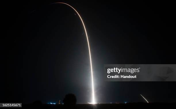 In this handout image provided by NASA, an eight-minute long exposure image shows a SpaceX Falcon 9 rocket carrying the company's Dragon spacecraft...