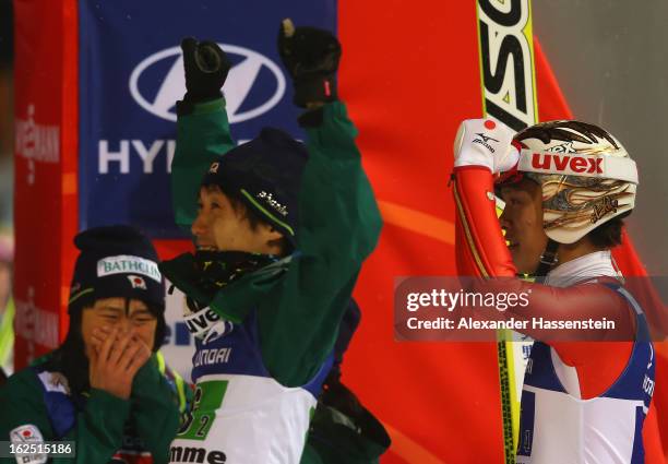 Taku Takeuchi , Sara Takanashi and Daiki Ito of Japan celebrate victory during the Mixed Team Ski Jumping HS 106 Final Round at the FIS Nordic World...