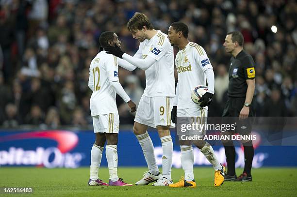 Swansea City's English midfielder Nathan Dyer is consoled by Swansea City's Spanish midfielder Miguel Michu after losing out on penalty-taking duties...