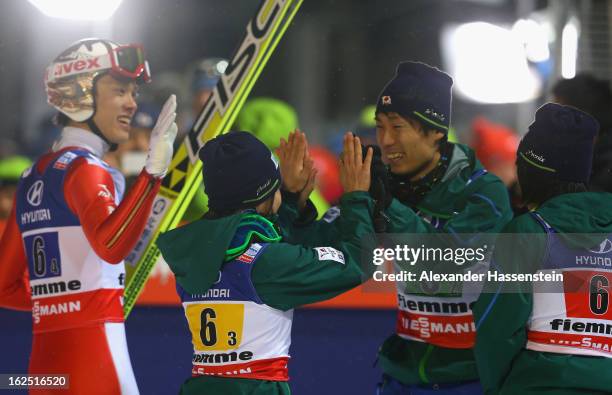 Taku Takeuchi , Sara Takanashi and Daiki Ito of Japan celebrate victory during the Mixed Team Ski Jumping HS 106 Final Round at the FIS Nordic World...