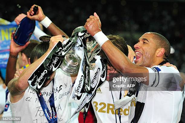 Swansea City's English-born Welsh defender Ashley Williams , Spanish striker Miguel Michu and Spanish defender Chico Flores celebrate with the trophy...